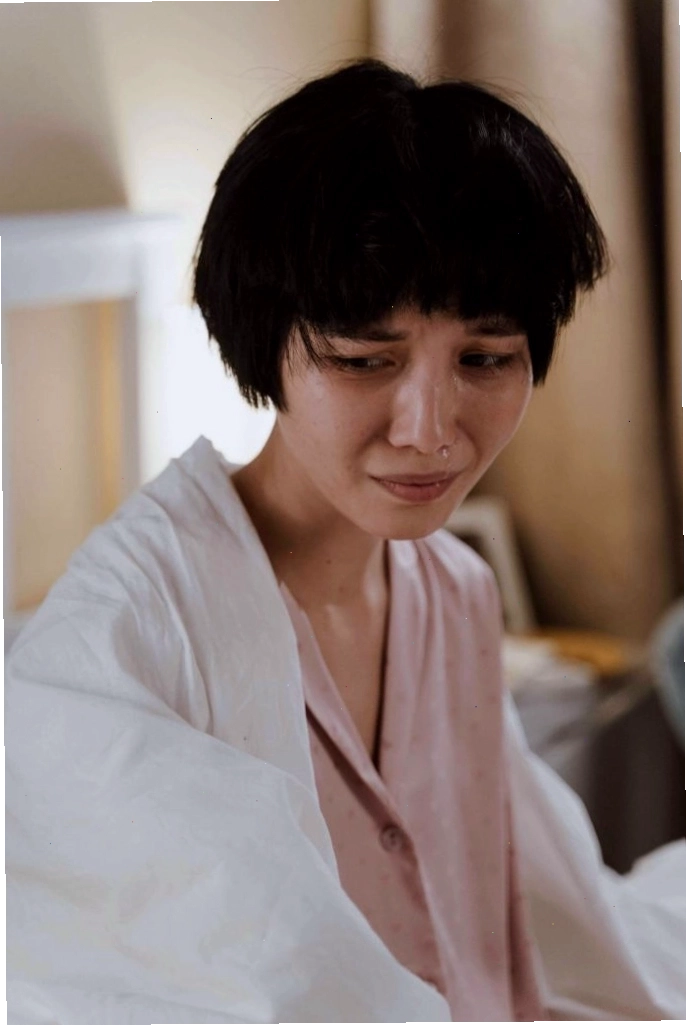 Cô gái ngồi một mình dưới mưa, thể hiện nỗi buồn sâu lắng