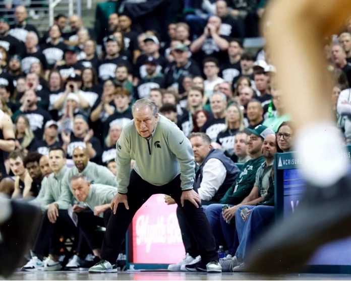 Chân dung huấn luyện viên Tom Izzo với nụ cười rạng rỡ bên cạnh danh hiệu vô địch